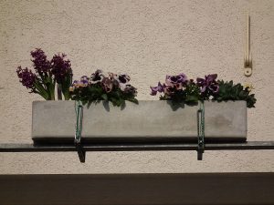 Çiçeklerle doldurulmuş bir balkon saksısı