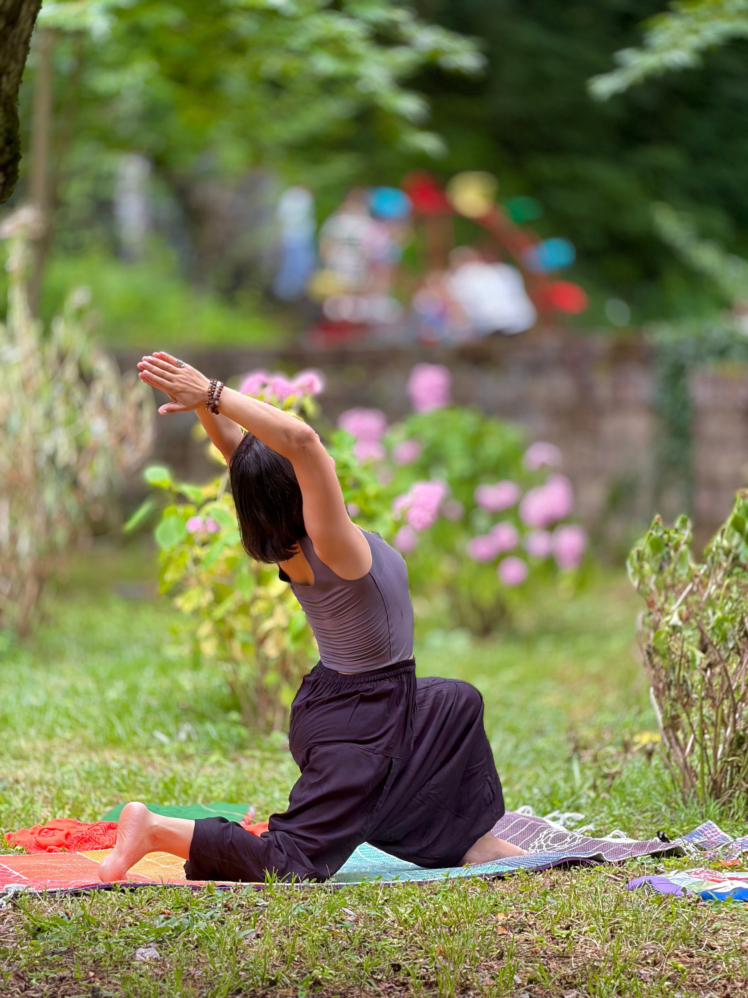 Yemyeşil bahçede yoga yapan kadın