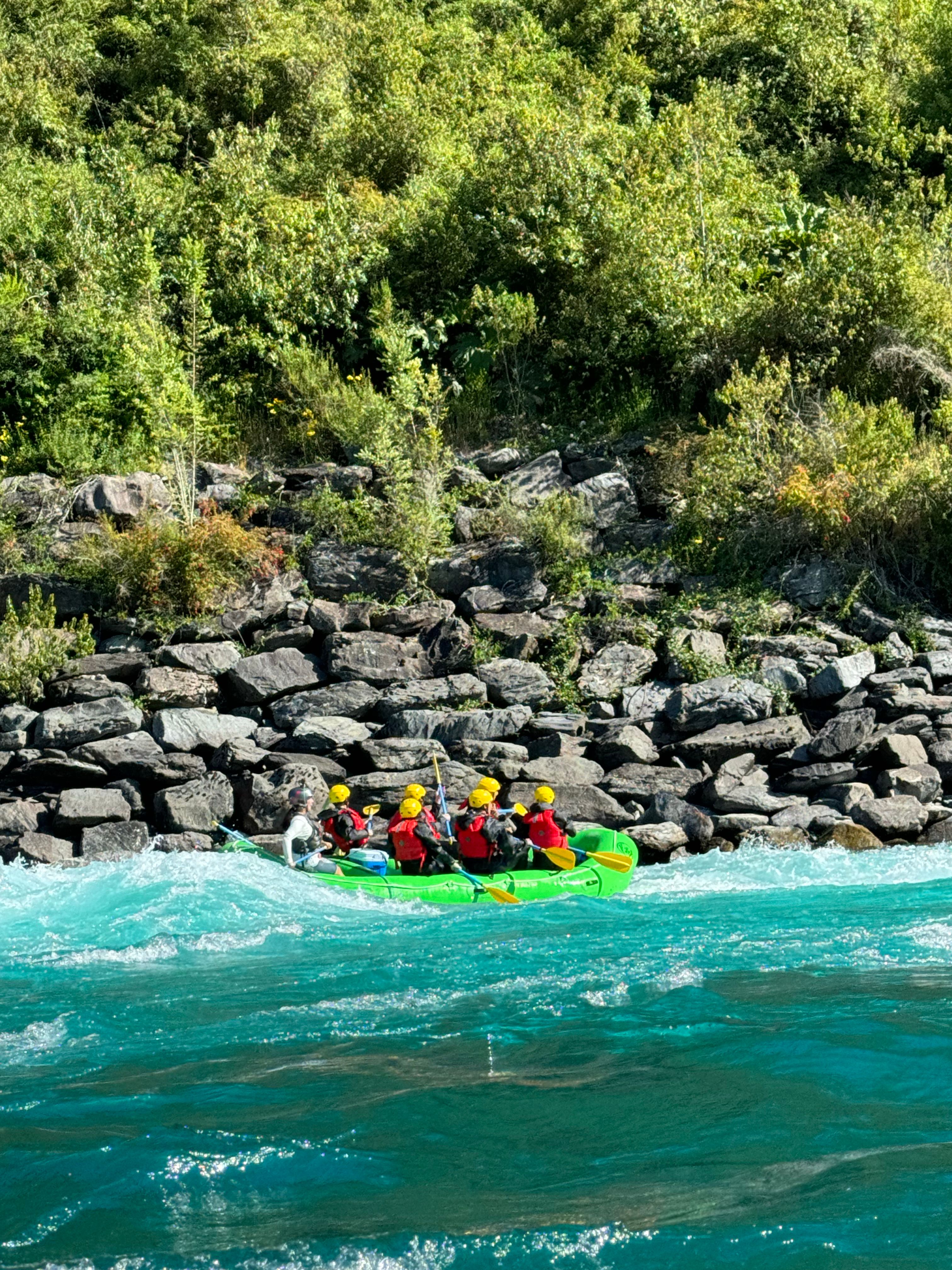 Şişme rafting botuyla hızlı akan nehirde ilerleyen ekip