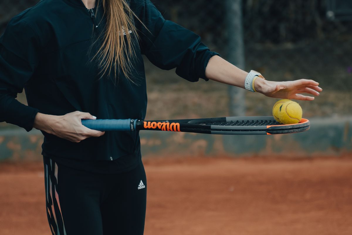 Elinde tenis raketi tutan bir sporcunun yakın çekimi