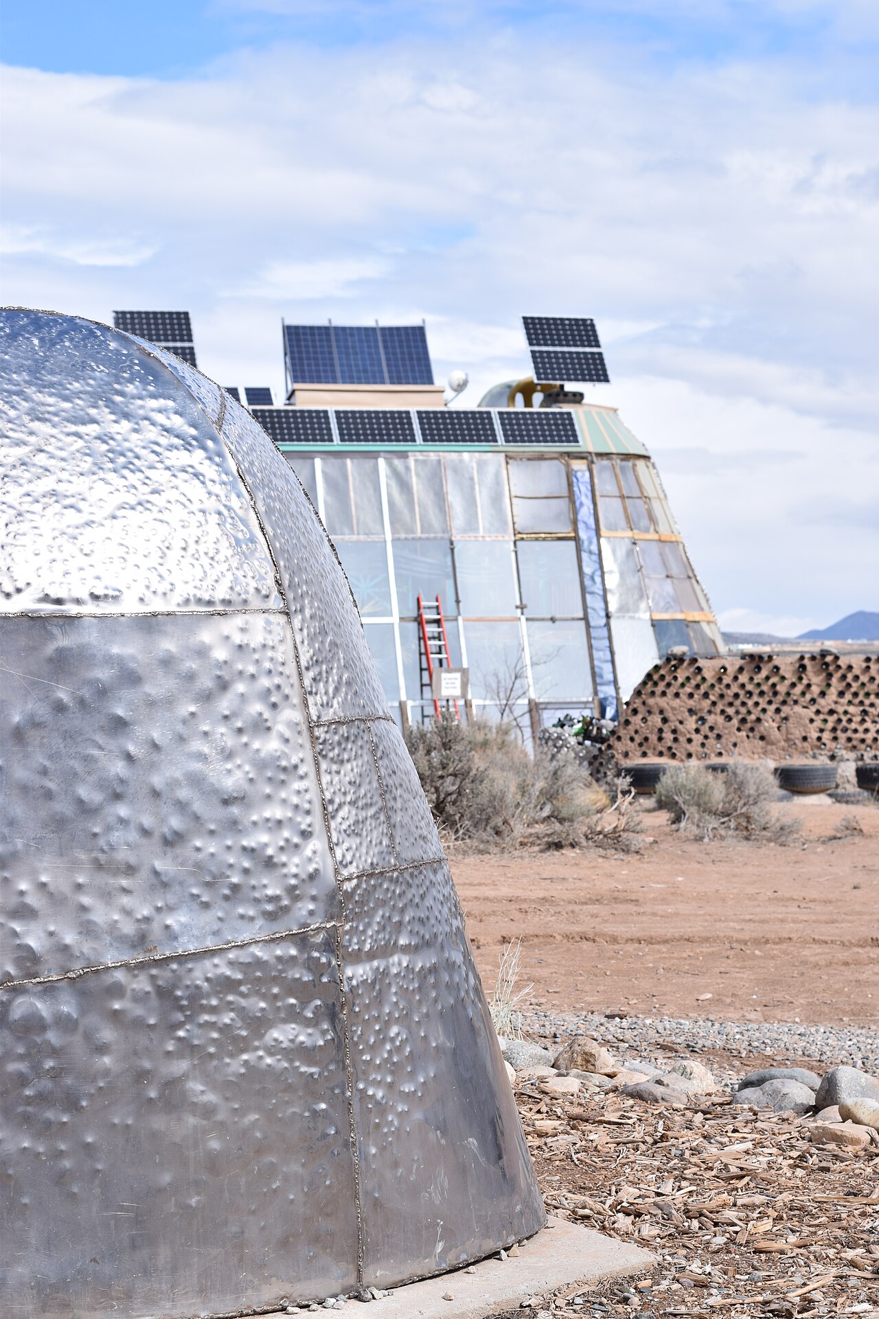 Earthship gunese donuk camekan ve topraga gomulu yapisi