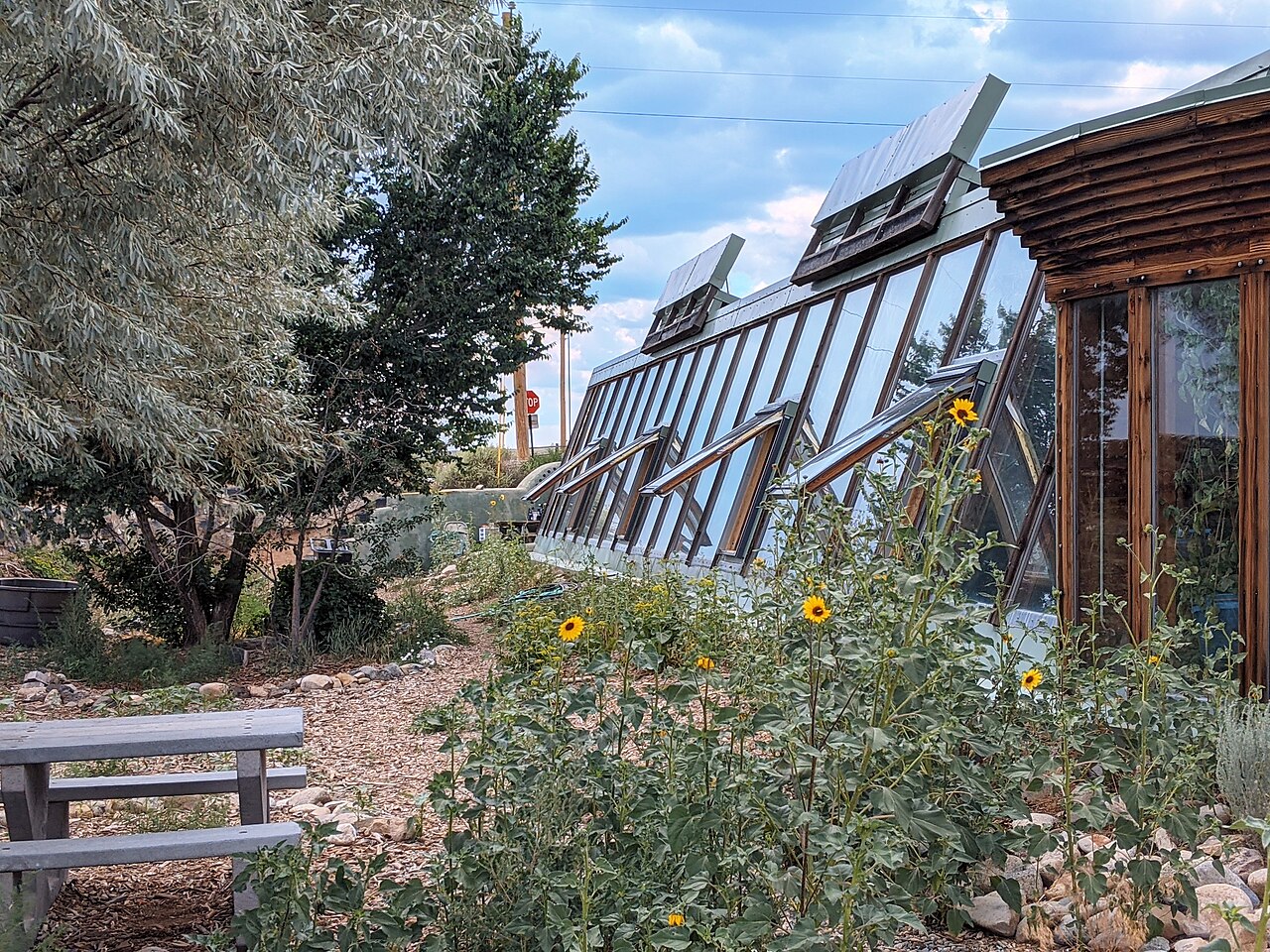 Earthship guneye bakan camlar, su varilleri, gunes panelleri